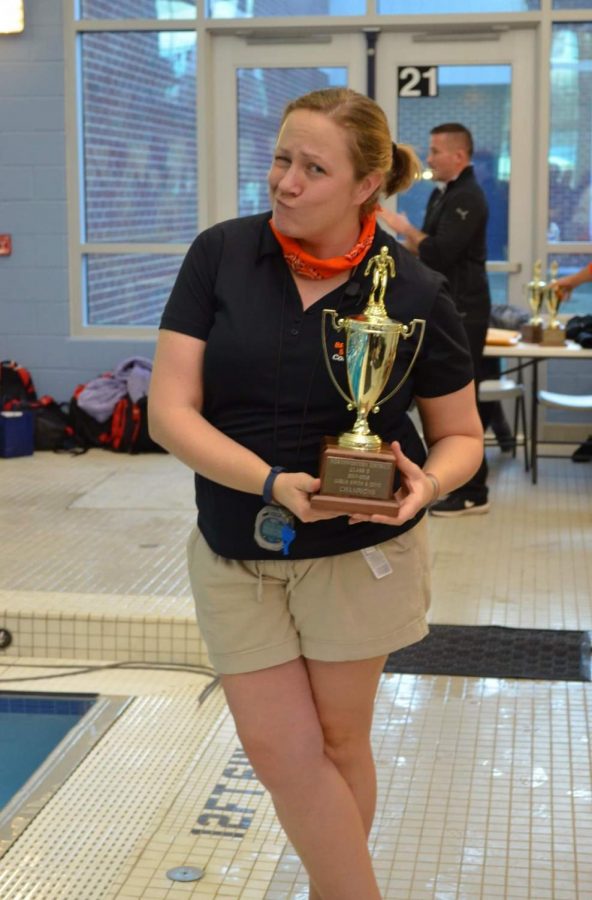 Swim coach Mrs. Livengood poses with their trophy after a successful meet. 