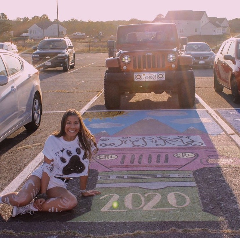 Senior Cassie Rozman paints her parking spot after her jeep.